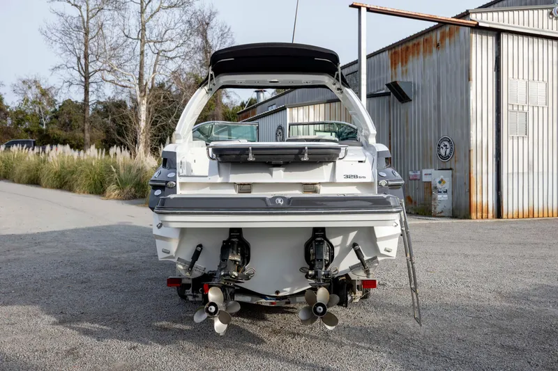 Slide: The Image of 2015 Monterey 328SS Super Sport boat, rear view, parked near industrial building. - 7