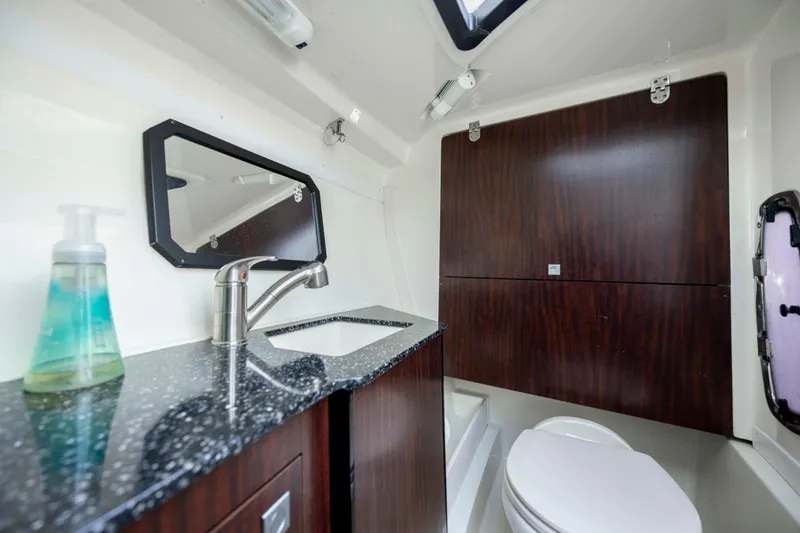 Slide: The Image of Luxurious bathroom in 2015 Monterey 328SS Super Sport boat with modern fixtures and wood accents. - 25