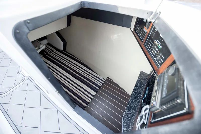 Slide: The Image of Interior cabin of 2015 Monterey 328SS Super Sport boat with striped bedding and control panels. - 27