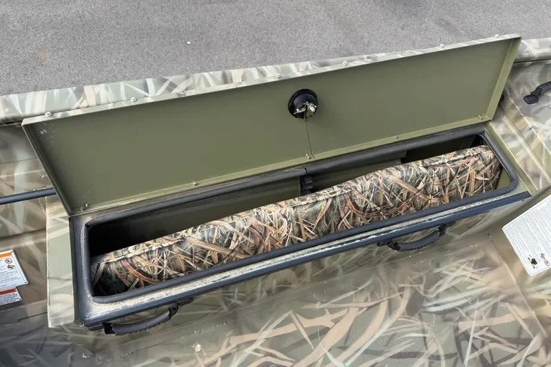 Slide: The Image of Open storage compartment in 2026 Crestliner 2070 Retriever SCHD boat with camouflage interior. - 13