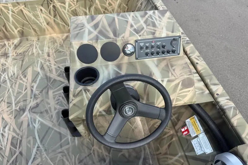 Slide: The Image of 2026 Crestliner 2070 Retriever SCHD boat console with camouflage design and steering wheel. - 11