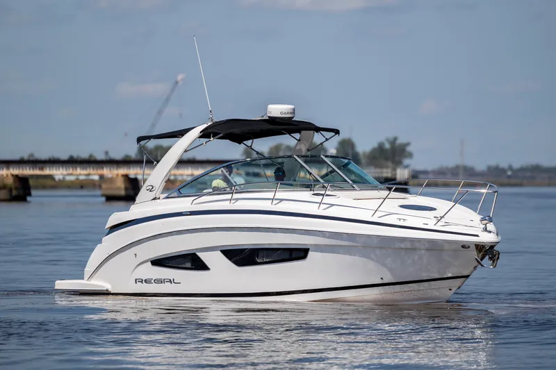 Slide: The Image of 2017 Regal 32 Express boat cruising on calm water, showcasing sleek design and modern features. - 3