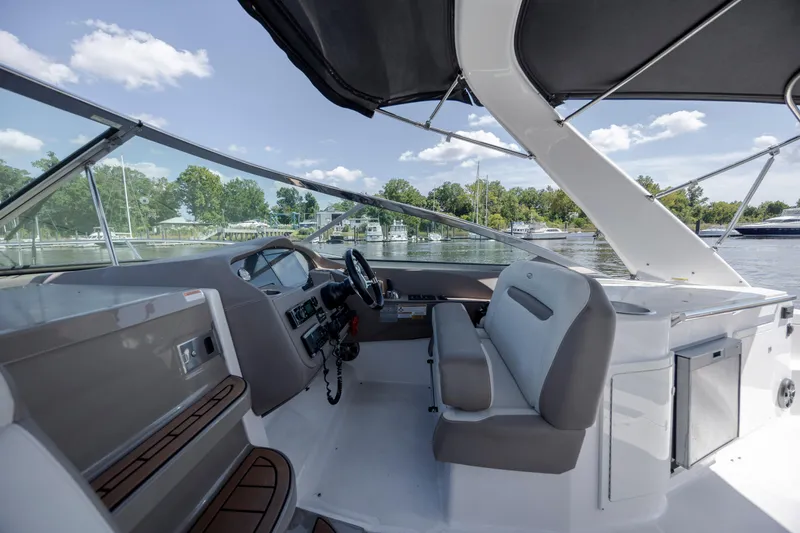 Slide: The Image of 2017 Regal 32 Express boat interior with helm, seating, and water view. - 18