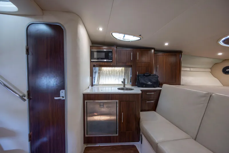 Slide: The Image of 2017 Regal 32 Express yacht interior with kitchenette, microwave, and seating area. - 25