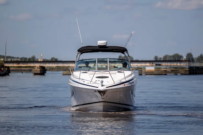 Slide: The Image of 2017 Regal 32 Express boat cruising on a calm river under a clear sky. - 5