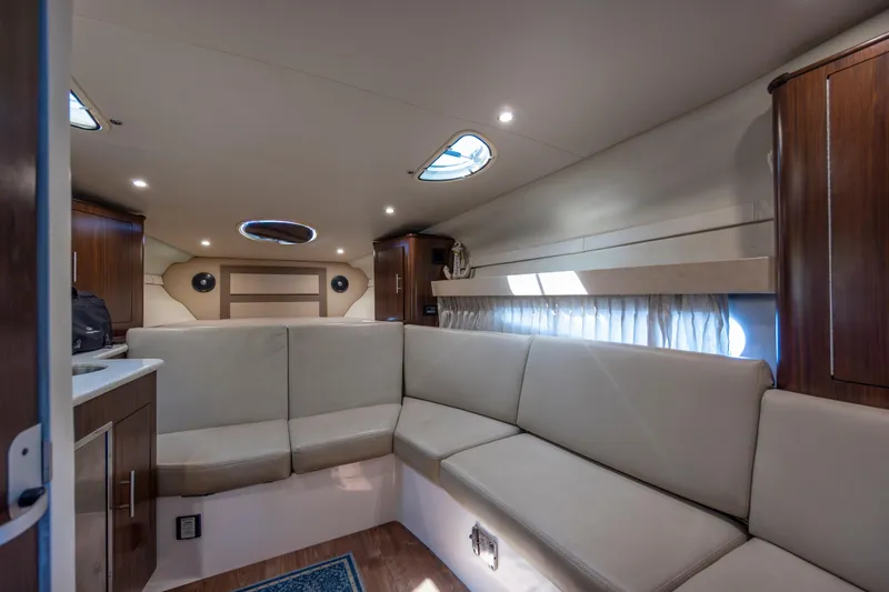 Slide: The Image of Interior of 2017 Regal 32 Express yacht with beige seating and wooden cabinets. - 23