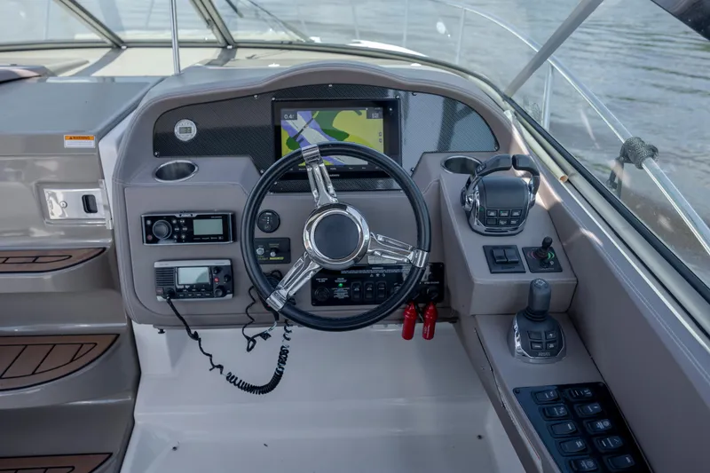 Slide: The Image of Cockpit of 2017 Regal 32 Express boat with steering wheel and navigation controls. - 9