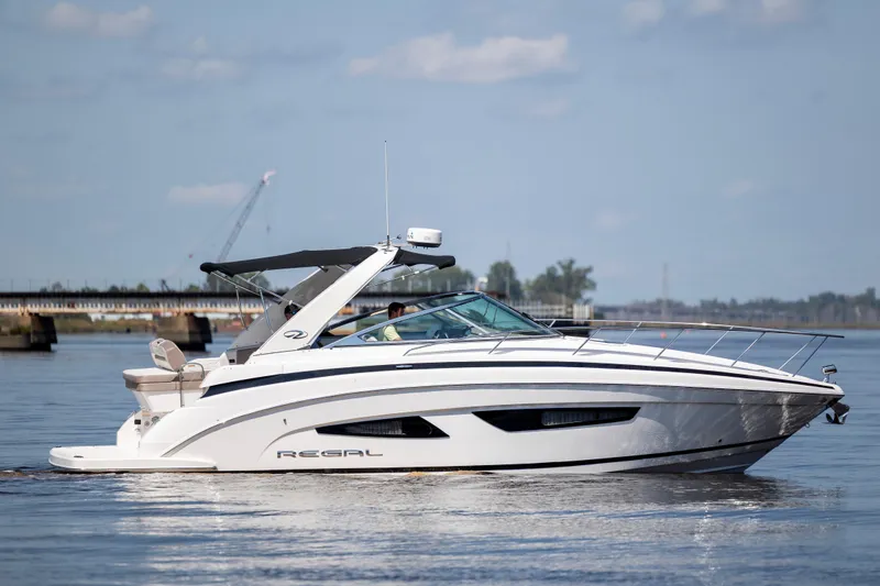 Slide: The Image of 2017 Regal 32 Express boat cruising on calm water under a clear sky. - 0