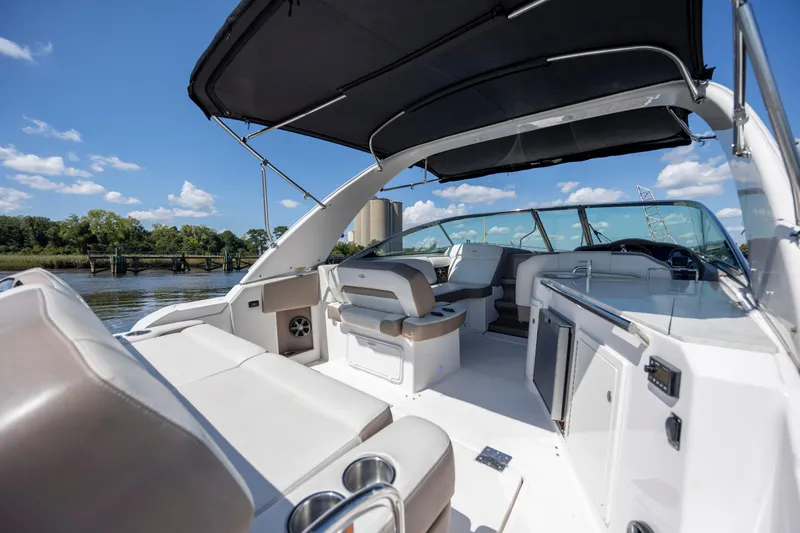Slide: The Image of 2017 Regal 32 Express boat interior with seating, canopy, and water view. - 7