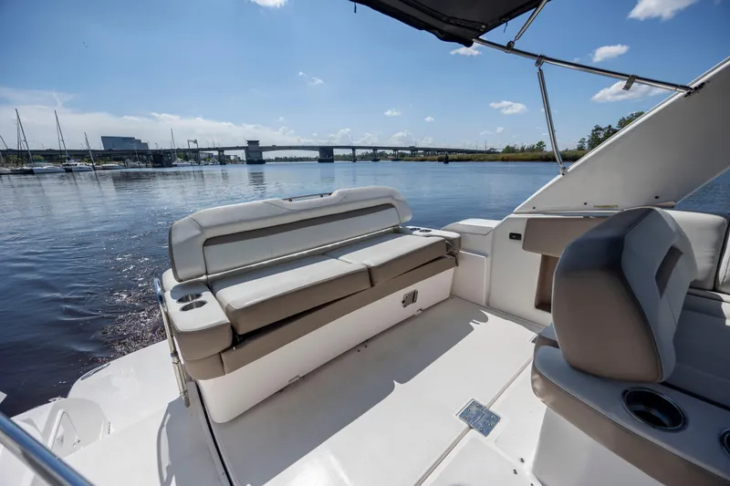 Slide: The Image of 2017 Regal 32 Express boat interior with seating, cup holders, and scenic water view. - 14