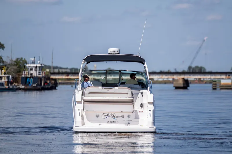 Slide: The Image of 2017 Regal 32 Express boat cruising on a calm waterway. - 6