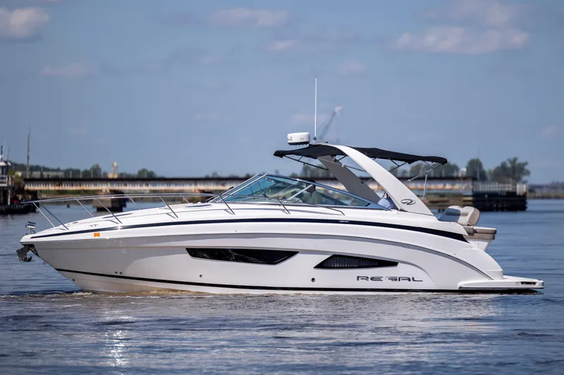 Slide: The Image of 2017 Regal 32 Express boat cruising on calm water under a clear sky. - 2