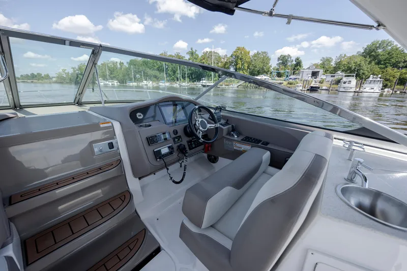 Slide: The Image of 2017 Regal 32 Express boat cockpit with steering wheel, dashboard, and water view. - 20