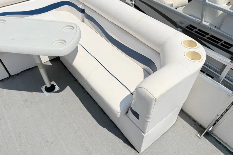 Slide: The Image of White seating area on a 2001 Harris Cruiser 220 boat with cup holders and table. - 10