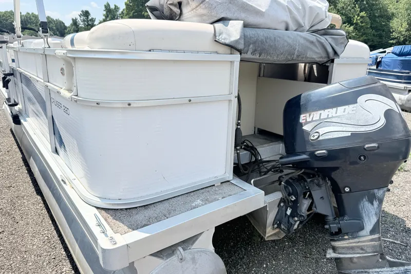 Slide: The Image of 2001 Harris Cruiser 220 pontoon boat with Evinrude outboard motor, parked outdoors. - 4