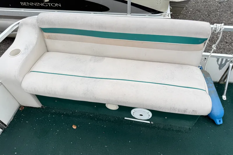 Slide: The Image of Worn seating on a 1999 Sweetwater Challenger 220 ES boat, featuring teal and beige upholstery. - 4
