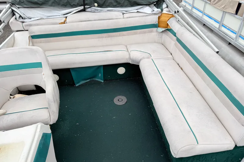 Slide: The Image of Interior of a 1999 Sweetwater Challenger 220 ES pontoon boat with white and teal seating. - 8