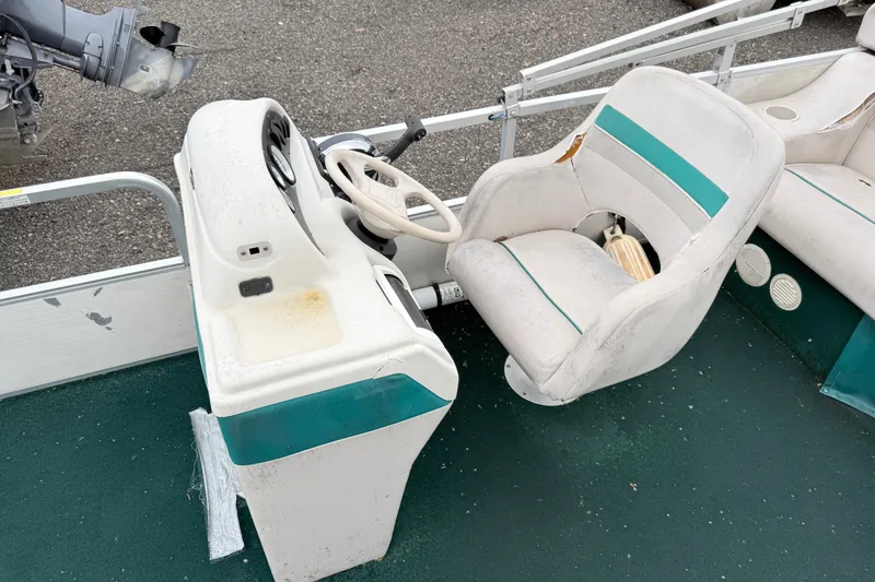 Slide: The Image of 1999 Sweetwater Challenger 220 ES boat interior with worn seats and steering console. - 7