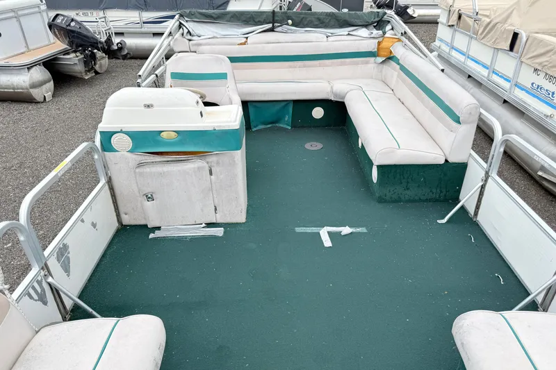 Slide: The Image of Interior of a 1999 Sweetwater Challenger 220 ES pontoon boat with green carpet and seating. - 6