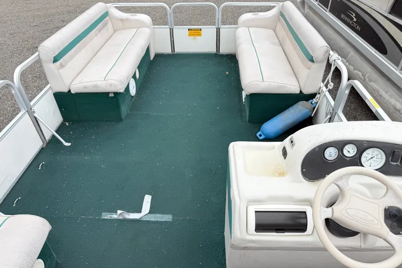 Slide: The Image of 1999 Sweetwater Challenger 220 ES pontoon boat interior with green carpet and white seating. - 10