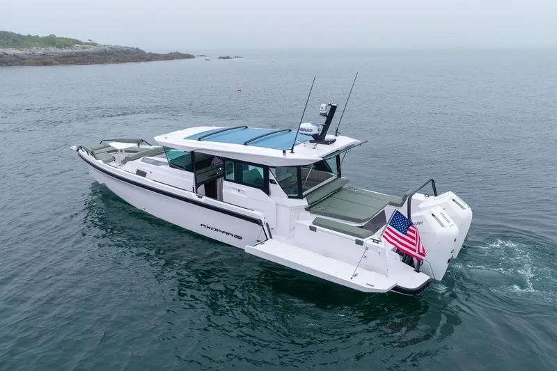 Slide: The Image of 2026 Axopar 38 Cross Cabin boat cruising on calm waters with American flag. - 4
