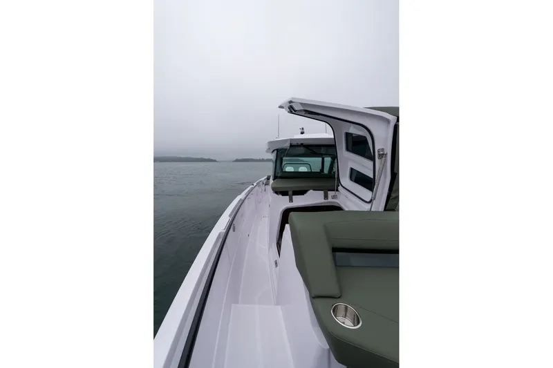 Slide: The Image of 2026 Axopar 38 Cross Cabin boat on calm waters, featuring sleek design and open cabin. - 13
