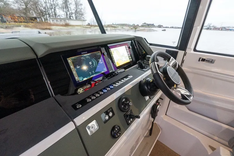 Slide: The Image of 2026 Axopar 38 Cross Cabin helm with advanced navigation displays and sleek steering wheel. - 40