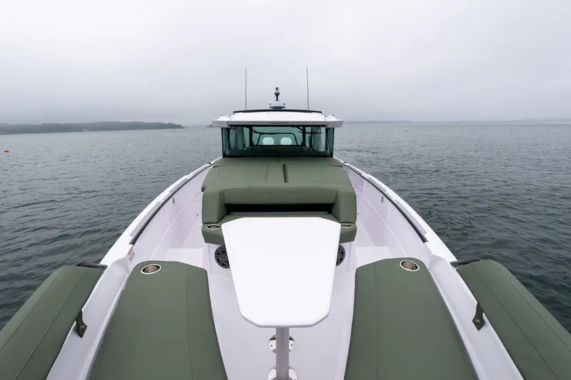 Slide: The Image of 2026 Axopar 38 Cross Cabin boat on calm water, featuring sleek design and spacious deck. - 11