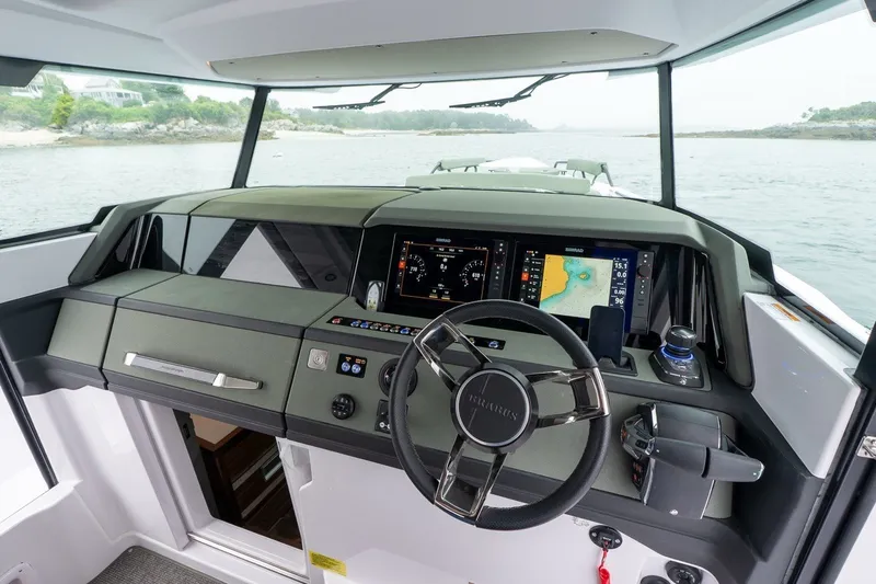 Slide: The Image of 2026 Axopar 38 Cross Cabin dashboard with navigation screens and steering wheel. - 24