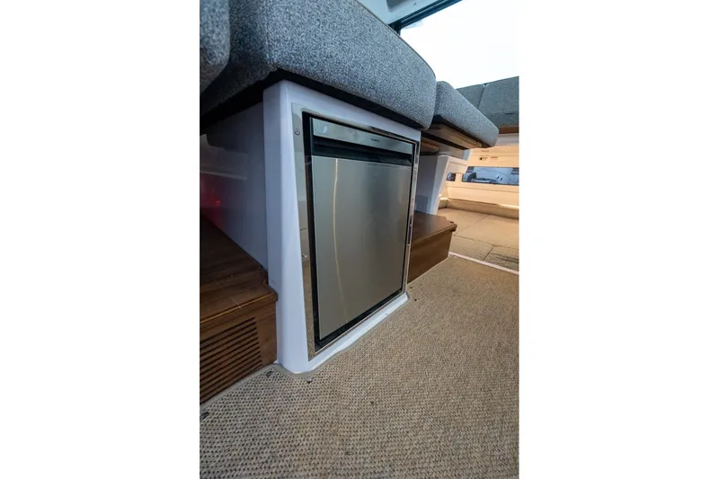 Slide: The Image of Interior view of 2026 Axopar 38 Cross Cabin featuring a compact refrigerator. - 31