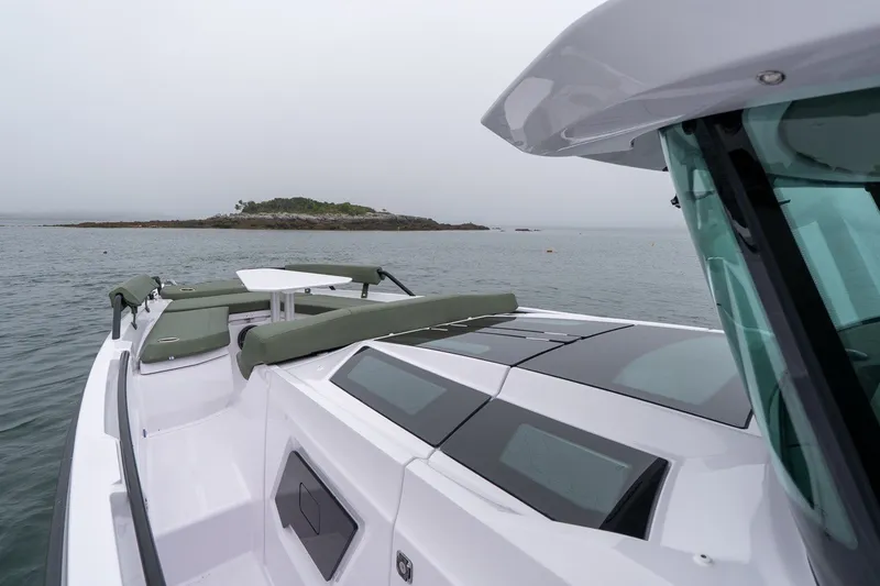 Slide: The Image of 2026 Axopar 38 Cross Cabin boat on calm waters near a small island. - 9