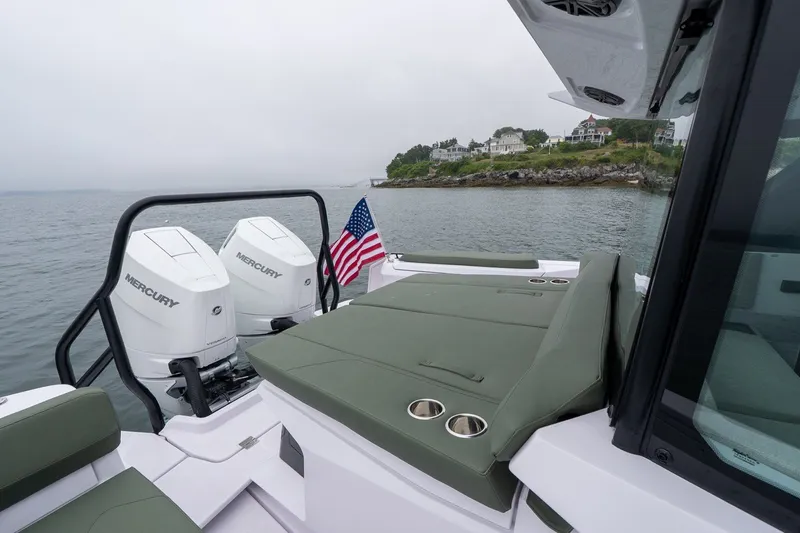 Slide: The Image of 2026 Axopar 38 Cross Cabin boat with Mercury engines, American flag, and coastal view. - 16