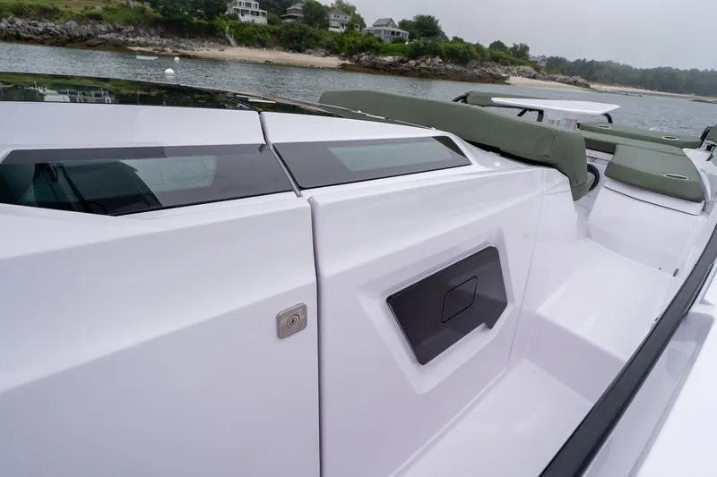 Slide: The Image of 2026 Axopar 38 Cross Cabin boat with sleek design and comfortable seating near a scenic shoreline. - 15
