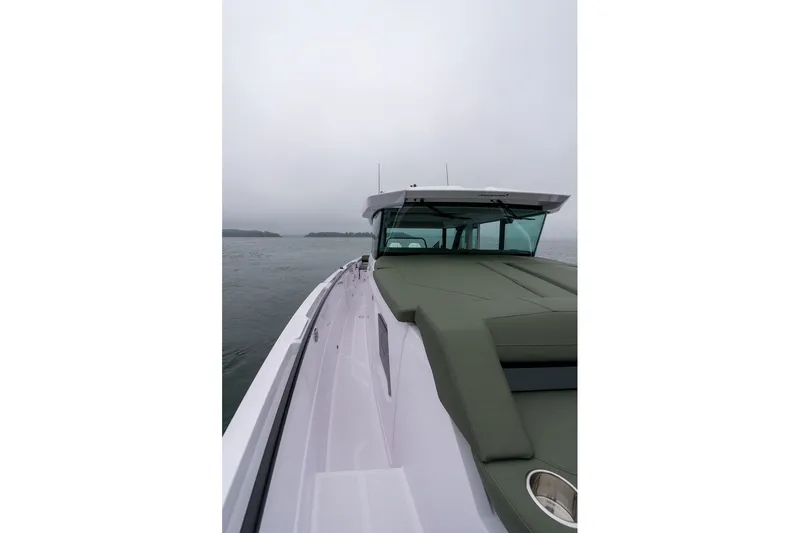 Slide: The Image of 2026 Axopar 38 Cross Cabin boat on calm waters under overcast sky. - 12