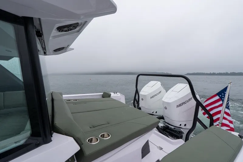 Slide: The Image of 2026 Axopar 38 Cross Cabin boat with Mercury engines and American flag on open water. - 17