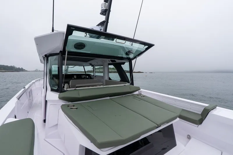 Slide: The Image of 2026 Axopar 38 Cross Cabin boat with green seating, open cabin, on calm waters. - 19