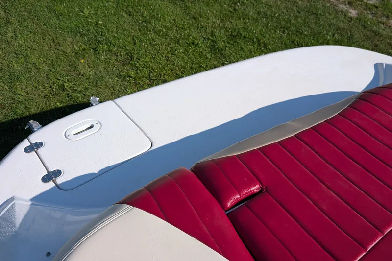 Slide: The Image of 2006 Four Winns 210 Horizon boat with red and white seating on grass. - 10