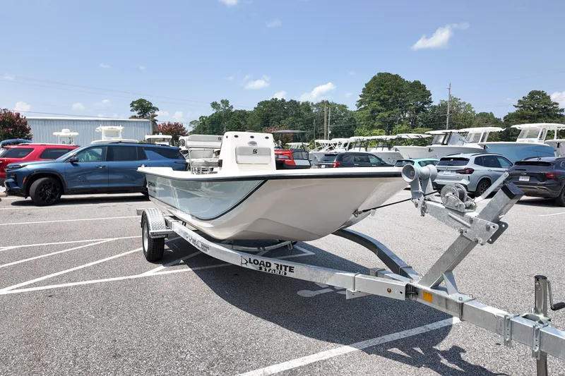 Slide: The Image of 2027 Carolina Skiff E18 JVX CC boat on trailer in parking lot, surrounded by cars. - 4