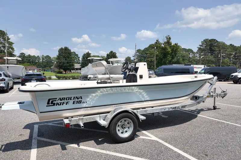 Slide: The Image of 2027 Carolina Skiff E18 JVX CC boat on trailer in parking lot, sunny day. - 3