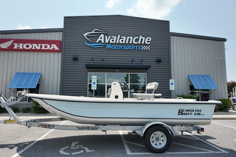 The Image of 2027 Carolina Skiff E18 JVX CC boat on trailer at Avalanche Motorsports dealership. - 1