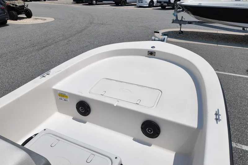 Slide: The Image of 2027 Carolina Skiff E18 JVX CC boat interior, featuring storage compartments and speakers. - 6