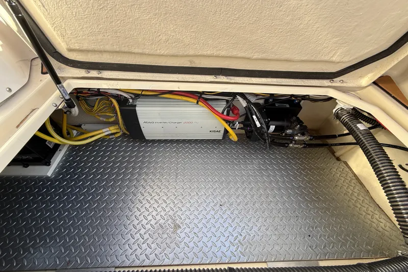 Slide: The Image of 2023 Ranger Tugs R-29 S engine compartment with inverter and wiring on diamond plate floor. - 10