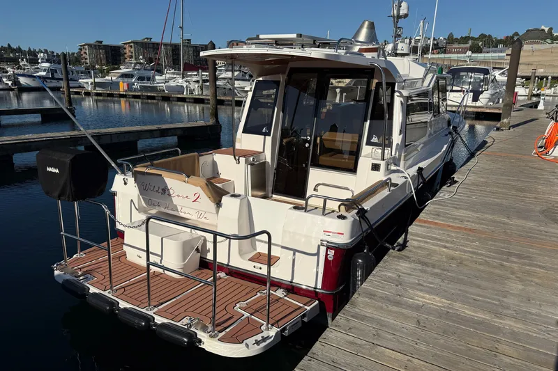 Slide: The Image of 2023 Ranger Tugs R-29 S docked at marina, rear view with wooden deck. - 3