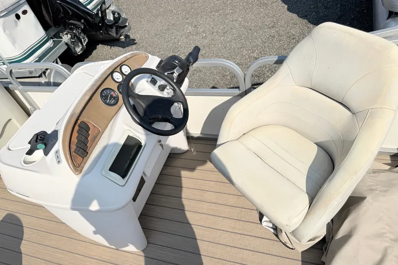 Slide: The Image of Steering console and seat of a 1999 Crest 240 boat, featuring gauges and controls. - 9