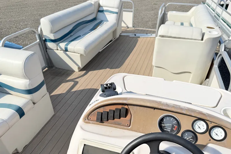 Slide: The Image of Interior of a 1999 Crest 240 boat with seating and dashboard controls. - 11