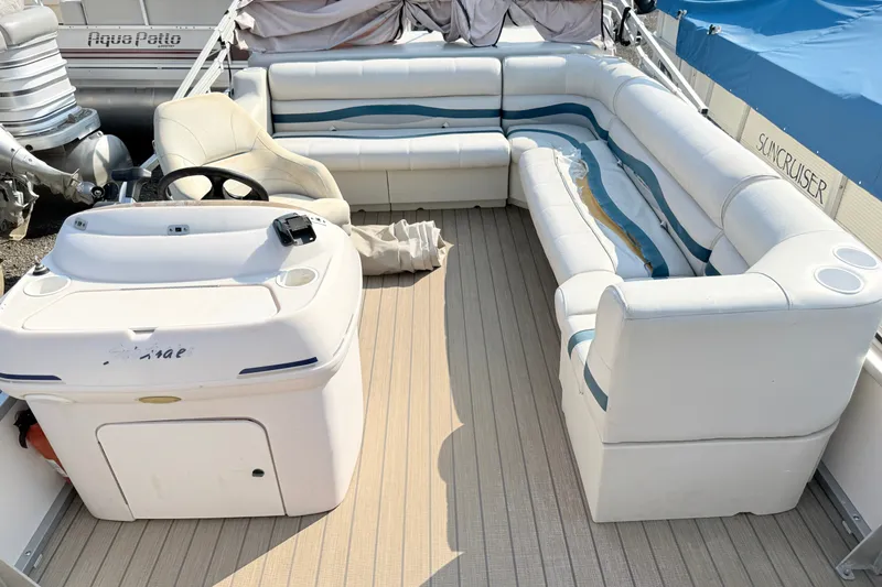 Slide: The Image of 1999 Crest 240 pontoon boat interior with white seating and steering console. - 6