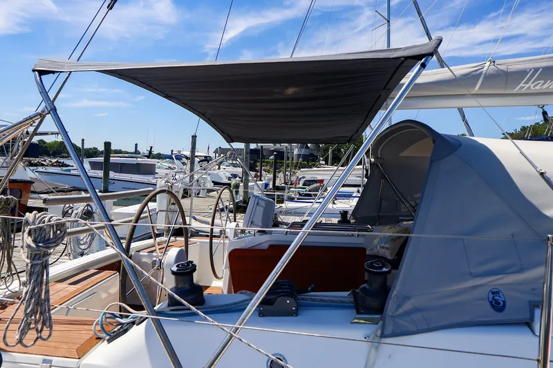 Slide: The Image of 2016 Hanse 385 sailboat docked, featuring dual steering wheels and a shaded cockpit. - 17