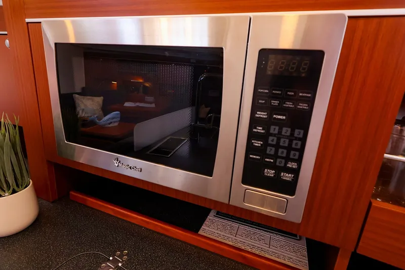 Slide: The Image of Built-in microwave in 2016 Hanse 385 yacht kitchen, featuring wood cabinetry and modern design. - 31