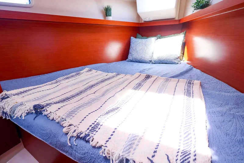 Slide: The Image of Cozy cabin interior of 2016 Hanse 385 yacht with blue bedding and decorative pillows. - 47