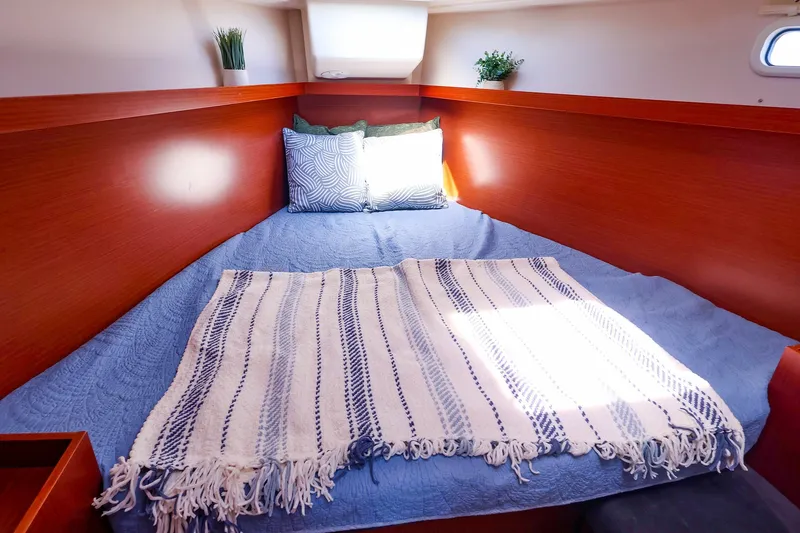 Slide: The Image of Cozy cabin interior of 2016 Hanse 385 yacht with blue bedding and decorative pillows. - 45